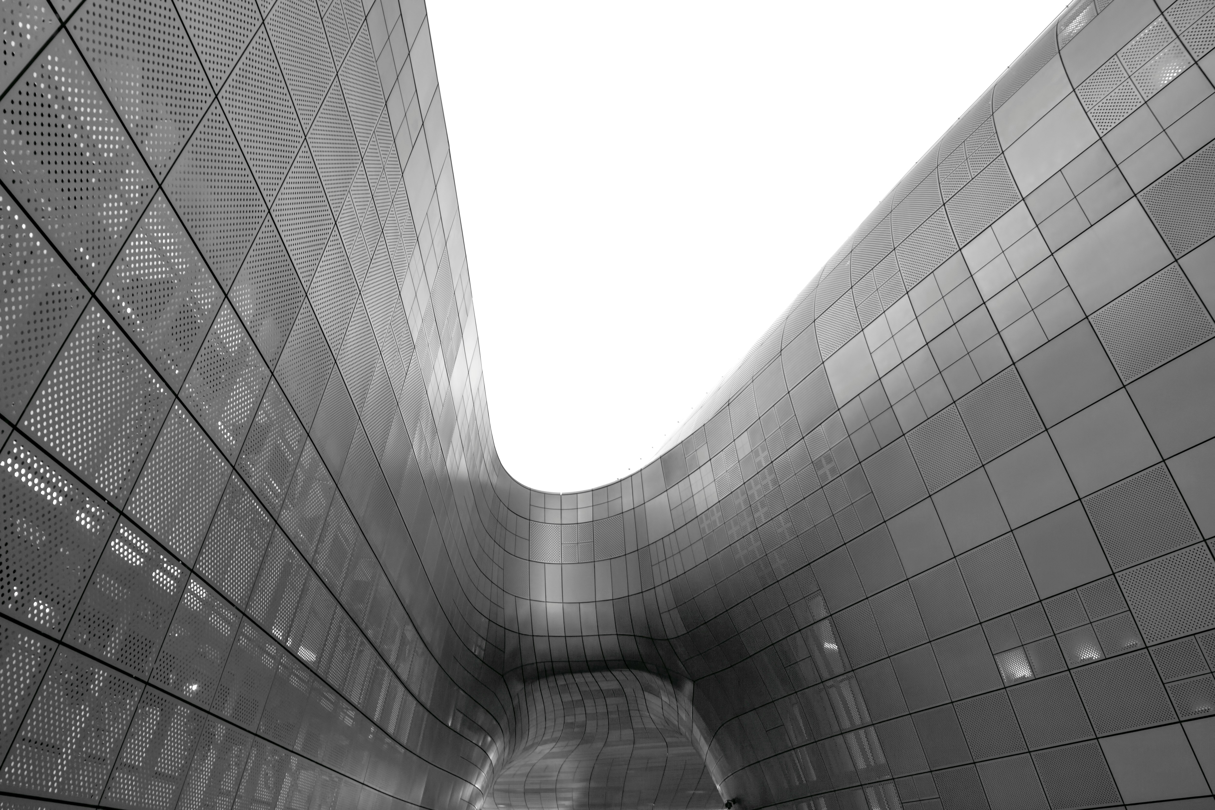 grayscale photo of glass walled building